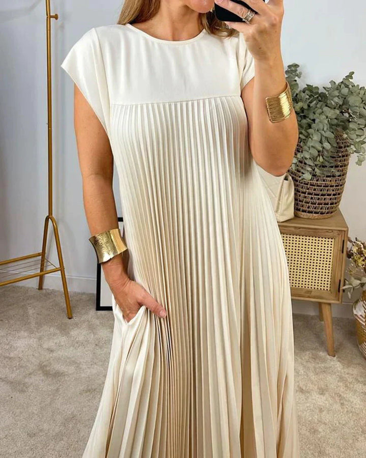 Cream sleeveless pleated maxi dress with round neck and vertical pleated bodice.
