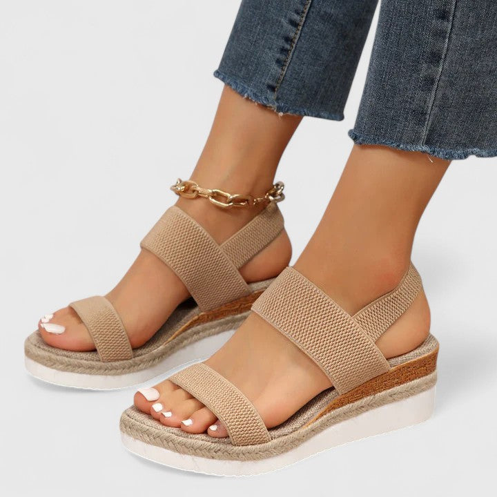 Orthopedic sandals in tan with two wide straps and gold chain ankle bracelet