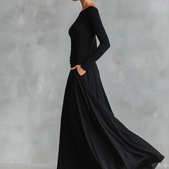 Black long-sleeve maxi dress, side view, flowing A-line skirt and ruched bodice