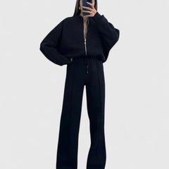 Zip-up sweater and drawstring pants set in black with hooded look and drawstring waist.