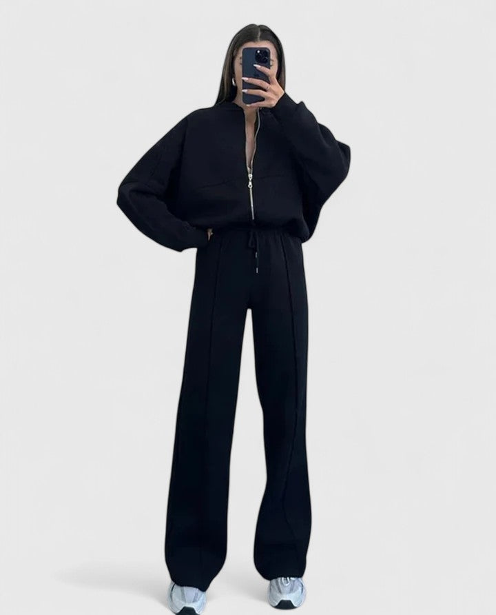 Zip-up sweater and drawstring pants set in black with hooded look and drawstring waist.