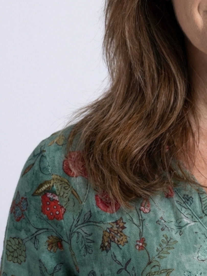 Floral print on teal-green maxi dress fabric with red and tan flowers