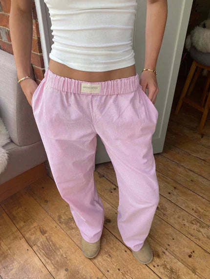 Pink lounge trousers with elastic waistband and relaxed straight legs, full length