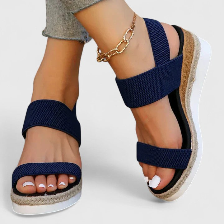 Orthopedic sandals in navy blue with wide straps and textured sole, gold chain ankle bracelet