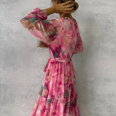 Floral tiered maxi dress in pink with belted waist and long sheer sleeves, back view