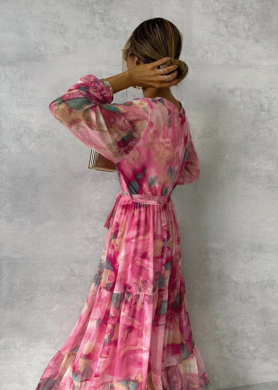 Floral tiered maxi dress in pink with belted waist and long sheer sleeves, back view