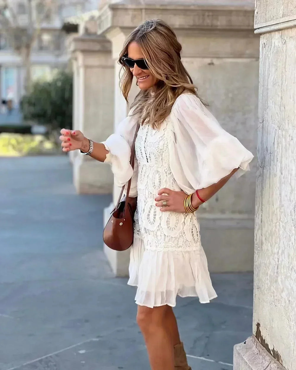 White embroidered lace mini dress with sheer sleeves, buttoned bodice, tiered hem
