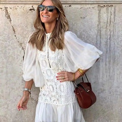 White embroidered lace mini dress with high collar, sheer sleeves, tiered skirt