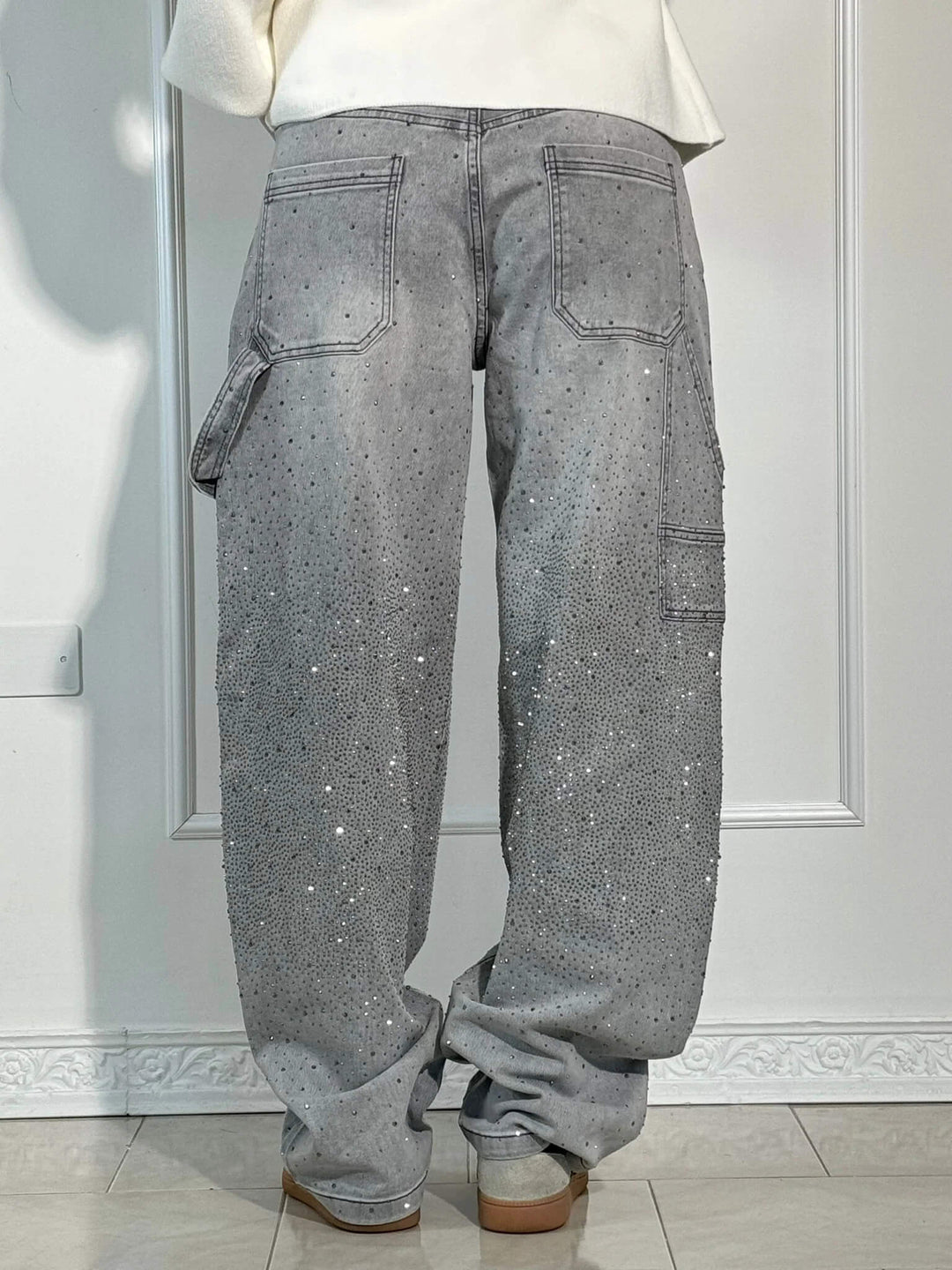 Gray speckled denim trousers with large flap cargo pockets and belt loops