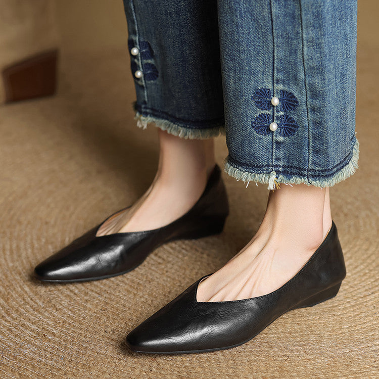 Black genuine leather mules on feet, almond toe slip-on design