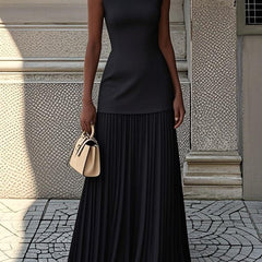 Black pleated sleeveless maxi dress with fitted bodice and tiered skirt.