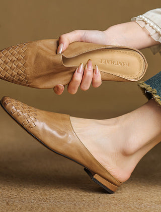 Tan leather slip-on mules with woven square toe and low heel, held in hand