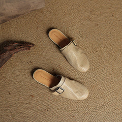 Beige leather mules with square buckle strap, pair on surface