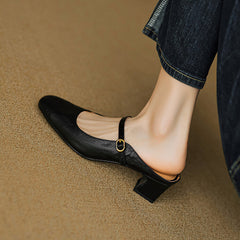 Black leather mule with rounded toe, low block heel, and buckled strap detail
