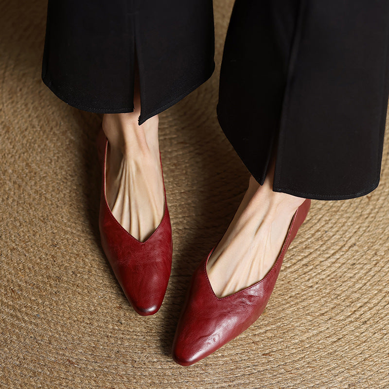 Maroon leather pointed-toe mules with low heel, worn with black pants