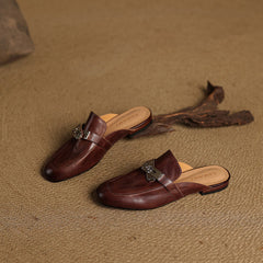 Pair of maroon leather mules with silver buckle straps, side view