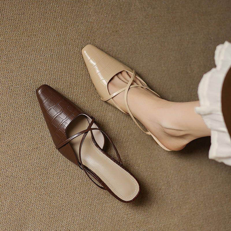 Beige and brown genuine leather mules with crisscross straps and mid heels, side view.