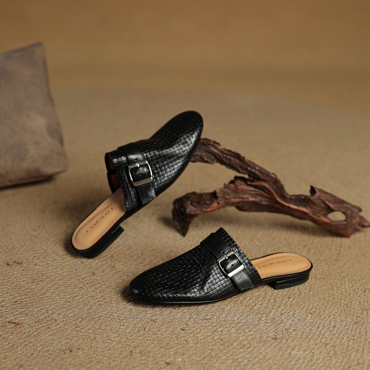 Black leather mules with square buckle strap, pair on surface