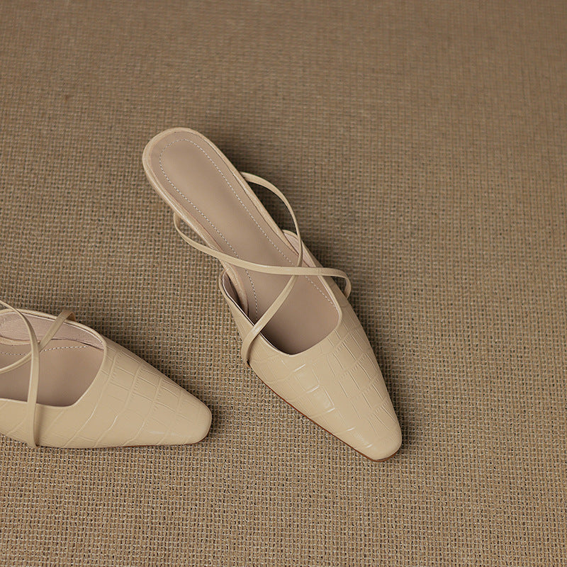 Pair of beige leather mules with crisscross straps and pointed toe, low heel