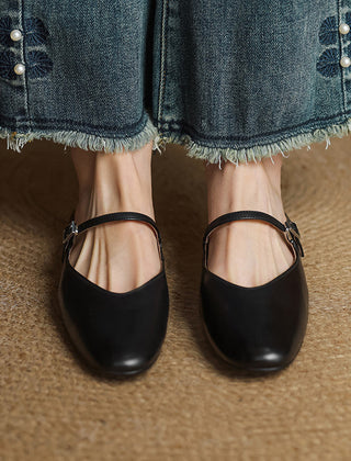 Black genuine leather mules with slip-on strap and buckle detail, worn with denim