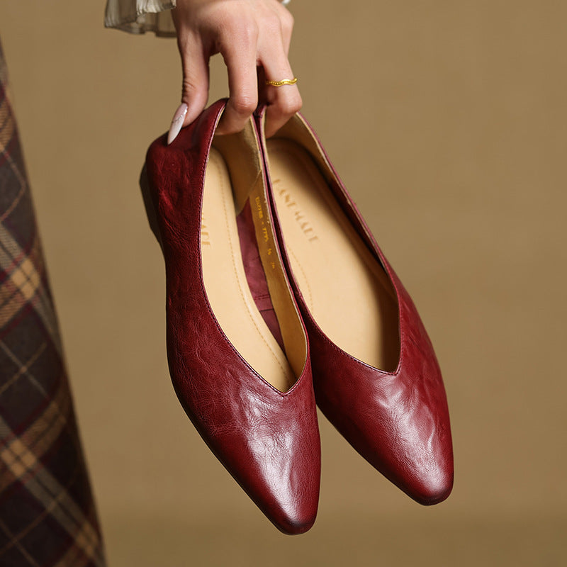 Maroon leather slip-on mules with pointed toe and flat, curved profile