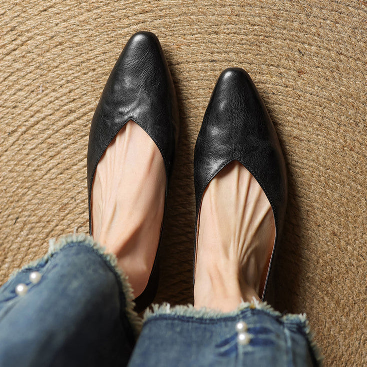 Black leather mules with pointed toe and open V-cut front for easy slip-on.