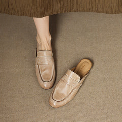Beige leather mule with slip-on design, low profile, and decorative seam lines