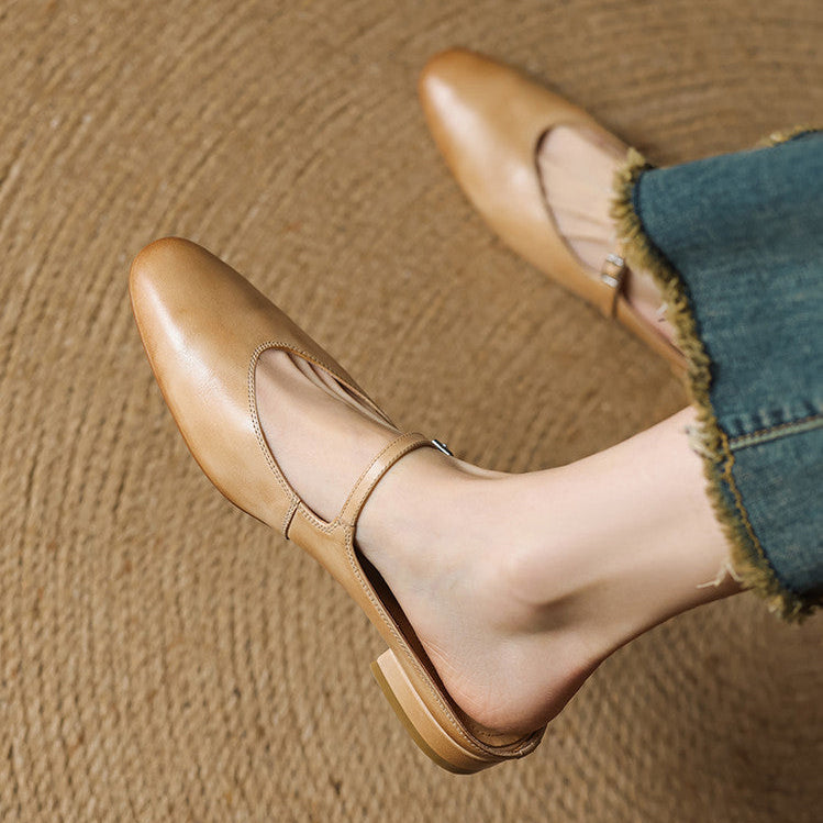Tan genuine leather mule close-up with adjustable strap, buckle, and almond toe