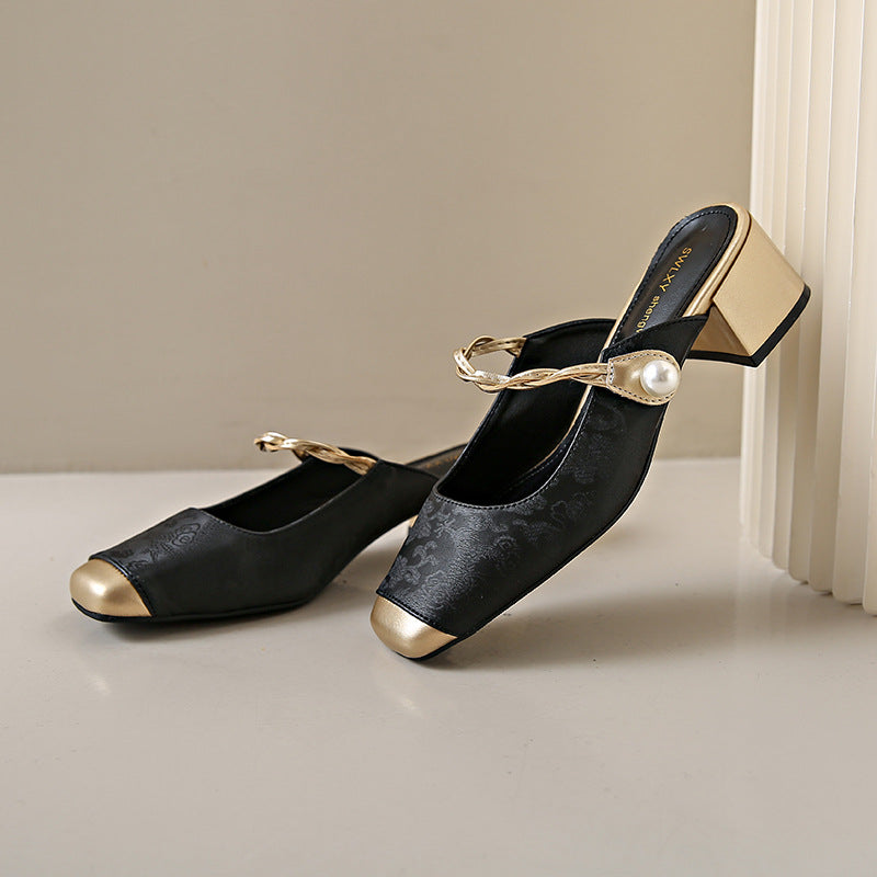 Black genuine leather mules with block heel, chain strap, and pearl detail across the instep.