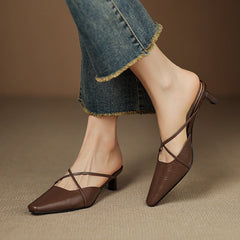 Brown genuine leather mule showing open back, crisscross strap, and mid heel.