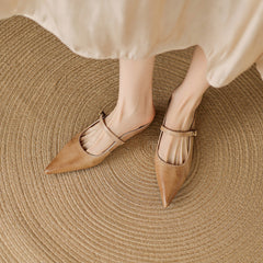 Pair of tan leather mules with pointed toe and ankle strap with buckle