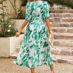Back view: green leafy print midi dress with gathered waist and short sleeves