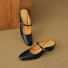 Black leather mule pair with rounded toe, low block heel, and oval buckle