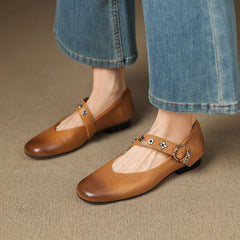 Tan leather flats with buckle strap and star-flower accents, low black sole