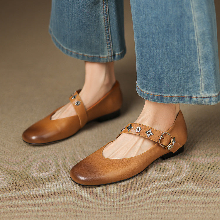 Tan leather flats with buckle strap and star-flower accents, low black sole