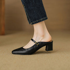 Black leather mule with low block heel and adjustable strap with gold buckle detail.