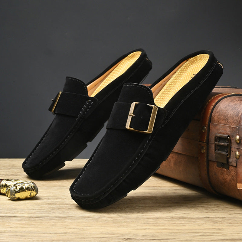 Pair of black suede mules with square metal buckle strap and tan-gold lining, slip-on