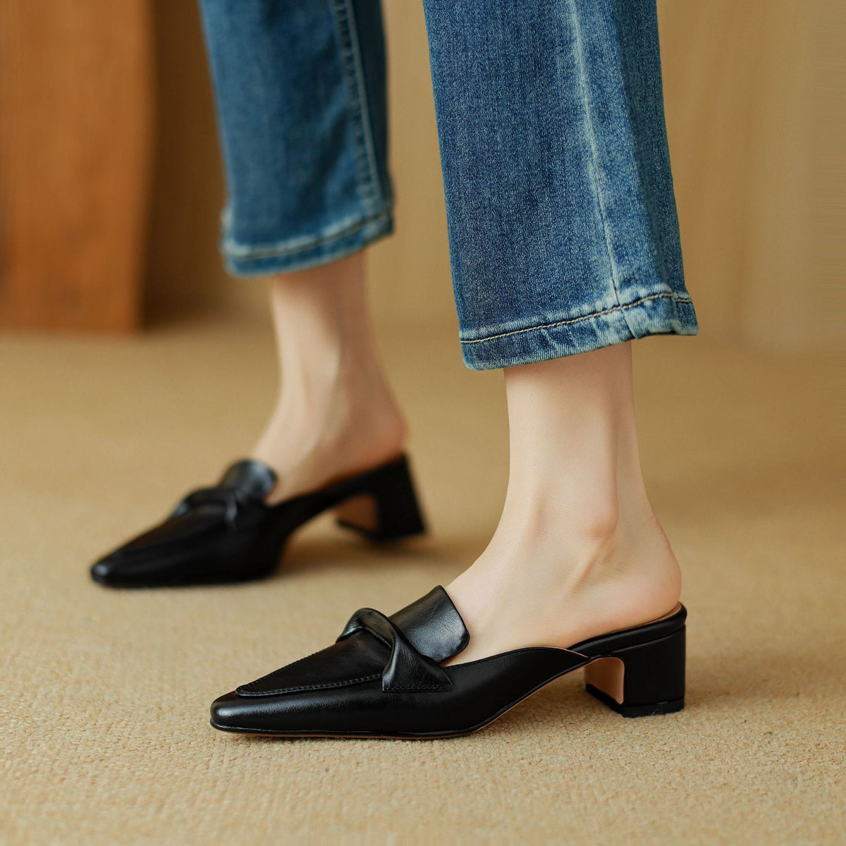 Black leather mule with pointed toe, slip-on design, and low block heel