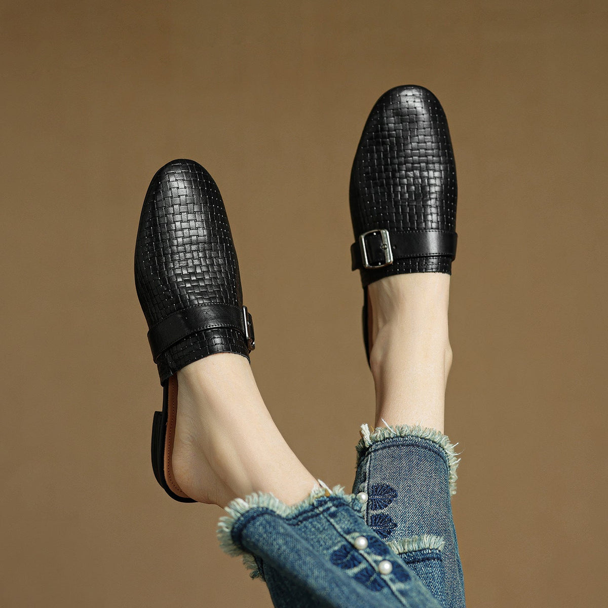 Black leather mules with textured finish and square buckle strap