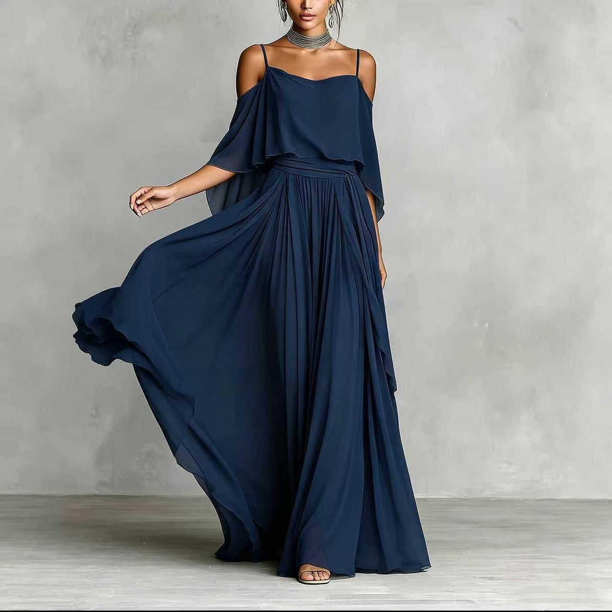 Navy blue draped cold-shoulder maxi dress with layered cape sleeves and pleated skirt