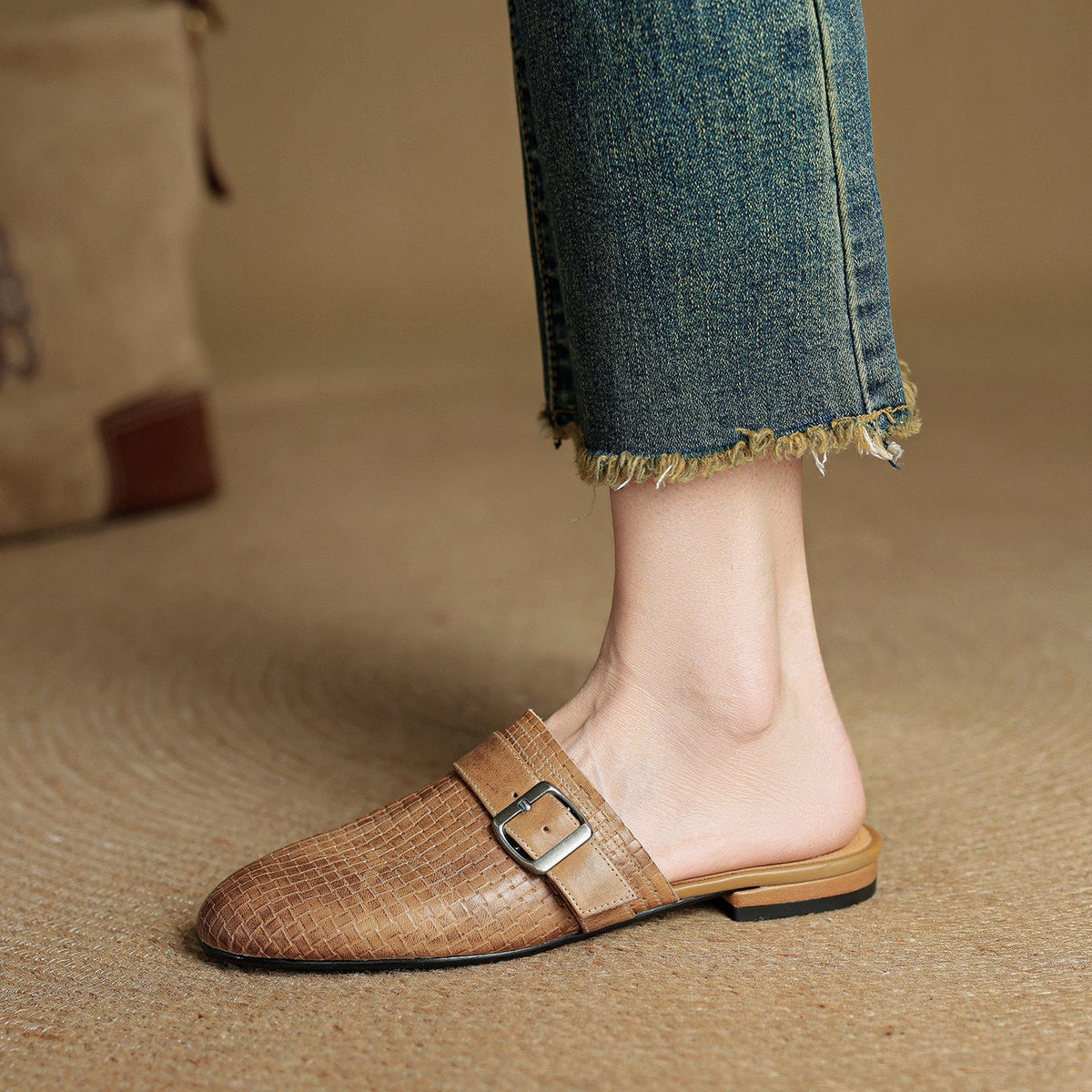Tan brown leather mule with adjustable buckle strap and flat sole