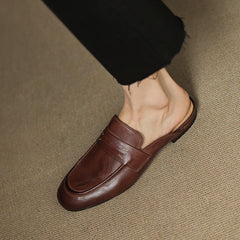 Brown leather slip-on mule with strap across the vamp and rounded square toe