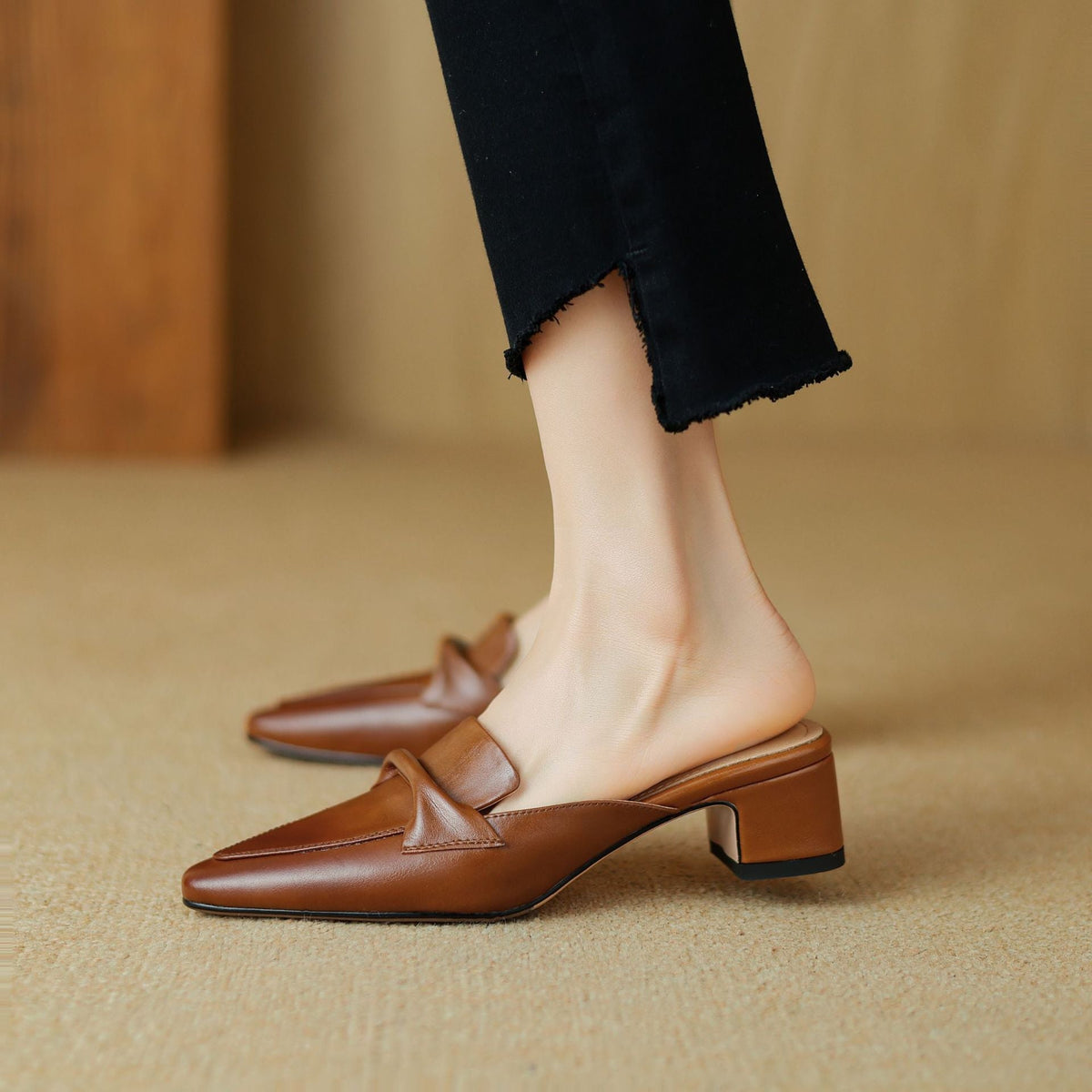 Brown leather mule with square toe and low block heel, slip-on design with strap detail
