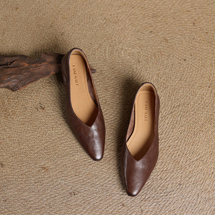 Dark brown genuine leather mules with almond toe, pair on textured surface