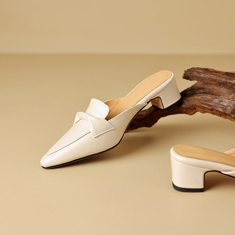 White leather mule with pointed toe, bow vamp strap, and low block heel