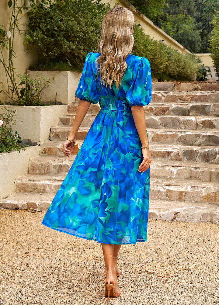 Back view of blue floral midi dress with puff sleeves and gathered waist, V-neck