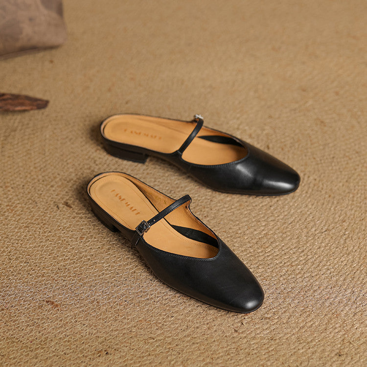 Black leather pointed-toe mules with thin T-strap, flat profile