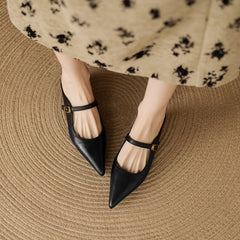 Black genuine leather mule with T-strap and small gold-tone buckle, pointed toe.