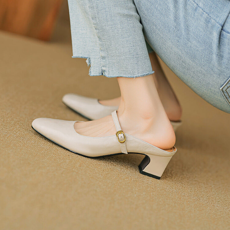 Beige leather mule with curved strap and gold buckle detail, low block heel.