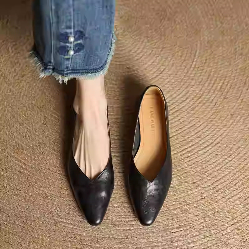 Pair of black leather pointed-toe mules with slip-on V-cut upper and low heel.